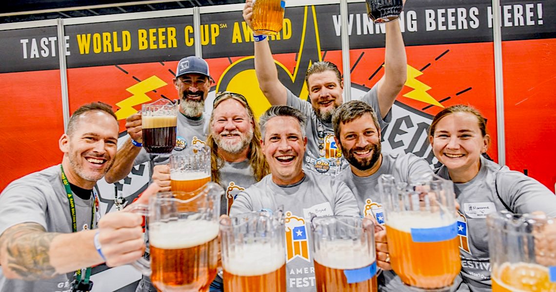 Birra e sorrisi si sprecano quando i birrai si accingono a ricevere il premio assegnato alle loro birre.